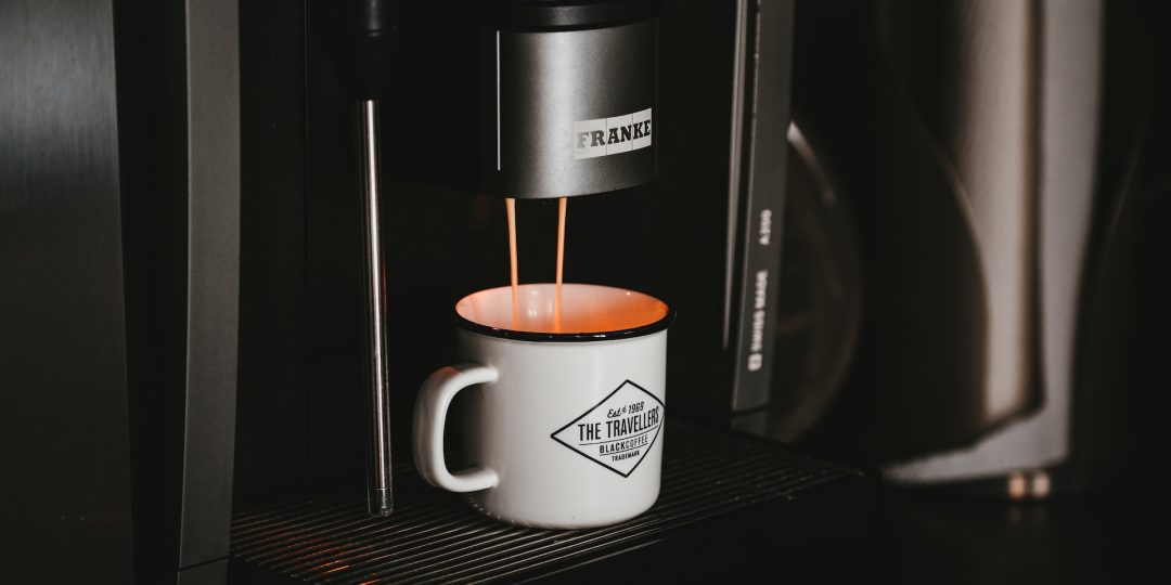 Coffee machine making coffee in a white coffee mug