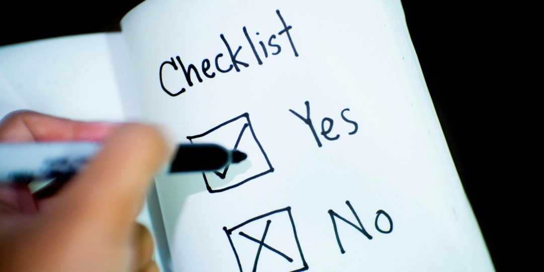 A person marking yes on a notebook with a checklist